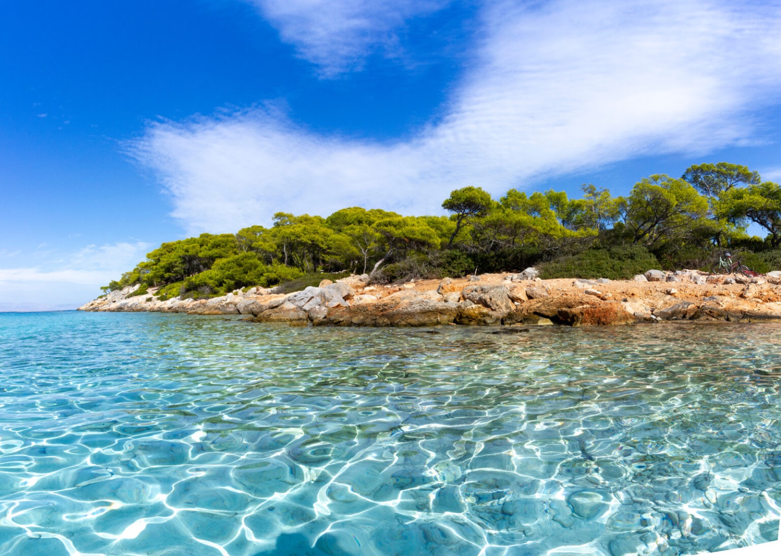 Turquoise water and the rocky shoreline at Aponisos on Agistri