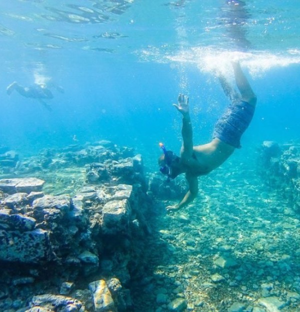 A snorkeller exploring submerged stone walls near Epidaurus